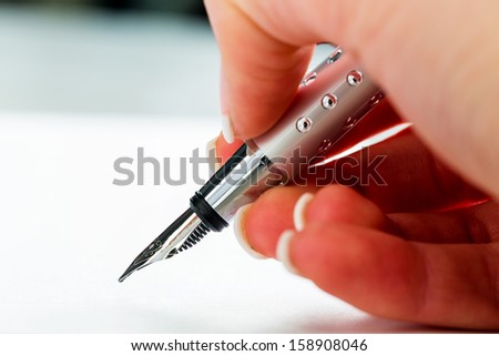 a hand with a fountain pen in the untrerschrift under a contract or testament.