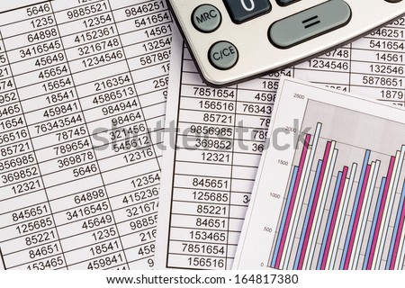a calculator is on a balance sheet figures are statistics. photo icon for sales, profit and cost.