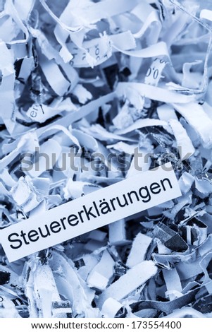 shredded paper tagged with tax returns, symbol photo for tax burden and retention requirements