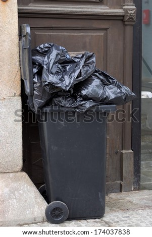 trash or garbage bins for household waste in front of a residential building