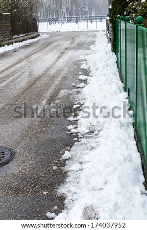 snow on sidewalk and street, symbol for accident risk and photo r?umpflicht