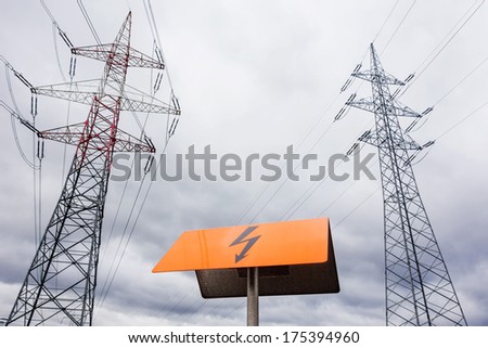the mast of a high voltage transmission line for electricity before dark clouds.