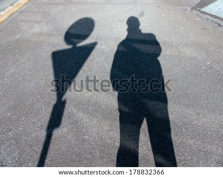 the shadow of a man on a sidewalk. anonymity of the big city.