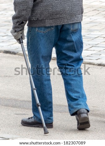 a man with a walking stick to help with walking difficulties eienr