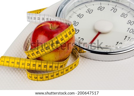 on a personal scale is an apple. symbolic photo for weight loss and healthy, vitamin-rich diet.