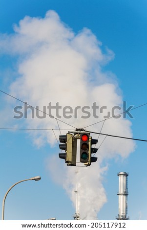 chimney of an industrial company and a red light. symbolic photo for environmental protection and ozone.