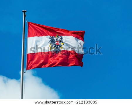 the austrian flag waving in the wind against a blue sky. flag austria