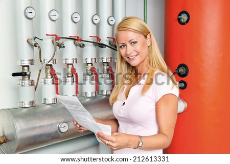 a young woman in the boiler room for heating. save energy