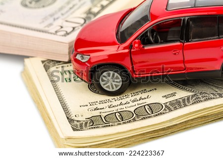a car stands on dollar banknotes. costs for the purchase of automobiles, gasoline, insurance and other car costs