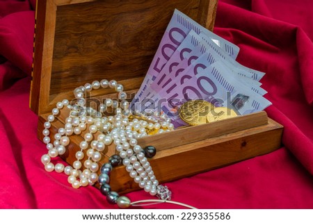 gold in coins and bars with decorations on red velvet. photo icon for wealth, luxury, wealth tax.