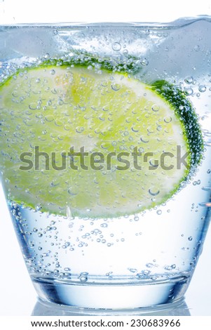 a glass of fresh drinking water and a lime. mineral water as a thirst quencher.