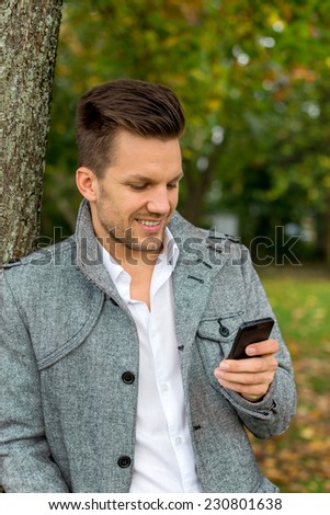 a man writes a text message on his cell phone. communication with a smart phone