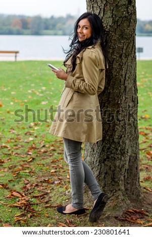 a young woman listens to music on your mobile phone. talking on the mobile phone.