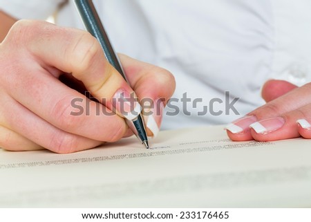 a woman signs a contract or a will with a fountain pen.