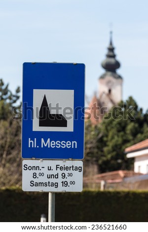 a sign announces the holy mass to be held in the parish church.