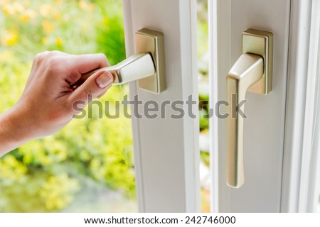 a woman opens a window to air the apartment. fresh air in the room