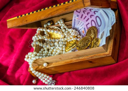 gold coins and bars with decorations on red velvet. photo icon for wealth, luxury, wealth tax