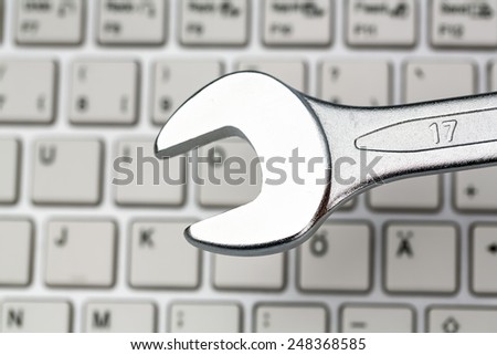 a wrench as a tool on a computer keyboard. symbolic photo for privacy, online crime and security on the internet