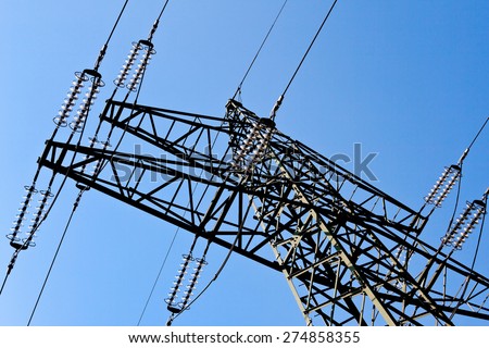 the poles of a power line against a blue sky. high voltage power line