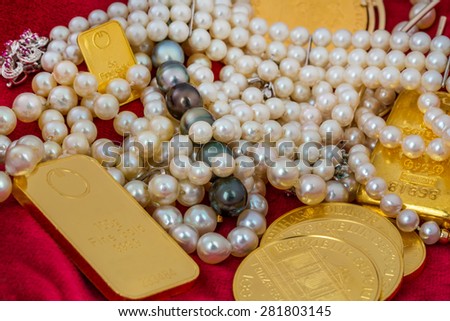 gold in coins and bars with decorations on red velvet. symbolic photo for wealth, luxury, wealth tax.
