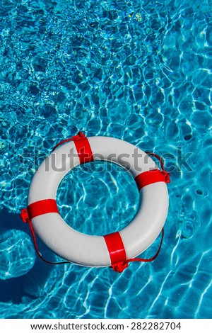 an emergency tire floating in a pool. symbolic photo for rescue and crisis management in the financial crisis and banking crisis.