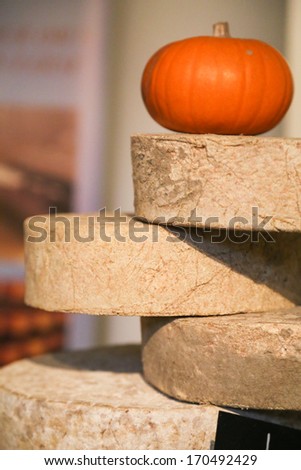 Pile of artisan cheeses topped by a pumpkin