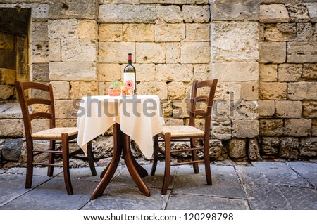 Table And Chairs In Front Of Historic Wall - Tuscany/Italy