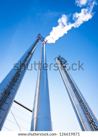 modern industry chimneys in front of blue sky