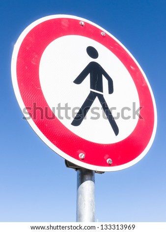 no pedestrian sign  in front of blue sky