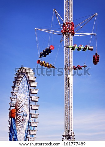 famous ferris wheel and a fairground ride at the oktoberfest in munich - germany