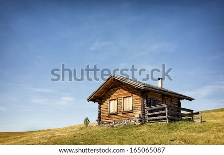 old log cabin at a meadow