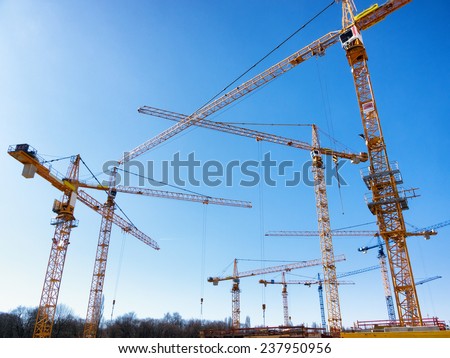 modern construction cranes in front of blue sky