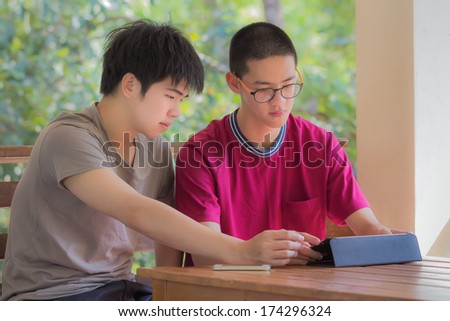 two cool young man at balcony playing tablet and smart phone
