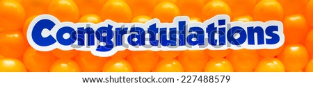 word of congratulations  on orange toy balloon background