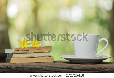 coffee cup book and yellow flower on table with sunlight