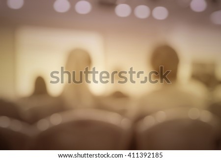 Blur vintage  image style of audience in classroom or auditorium with screen, brown color