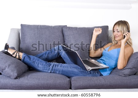 happy woman on her couch with her cellphone and laptop