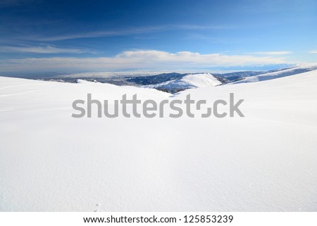 Candid off-piste ski slope in powder snow and scenic alpine background