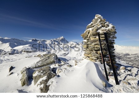 Wide angle view of a pair of back country ski on the top of the mountain in a clear bright day and scenic winter background