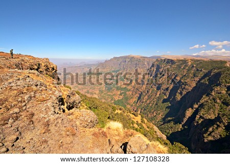Wide angle view from the Simien Mountain National Park in the dry season with armed ranger on the ridge