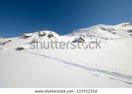 Little chapel high in the mountains with powder snow and back country ski tracks near Gran Paradiso National Park. Location: italian western Alps, Torino Province, Piedmont.