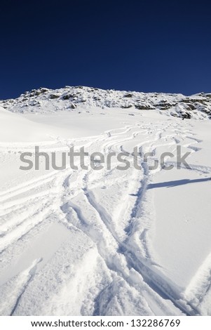 Zig zag shaped back country ski tracks in candid powder snow in a bright sunny day. Location: italian Alps, Piedmont