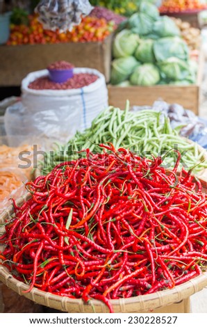 Heap of red chili peppers (Thai) in a basket ready for sell in indonesian street market. Selective focus, natural light.