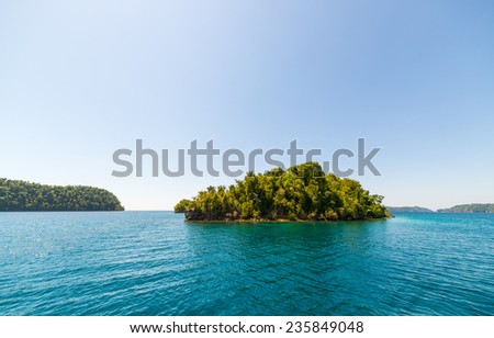 The stunning colors of the sea in the remote Togean Islands (or Togian Islands), Central Sulawesi, Indonesia. Desert islet covered by dense jungle.