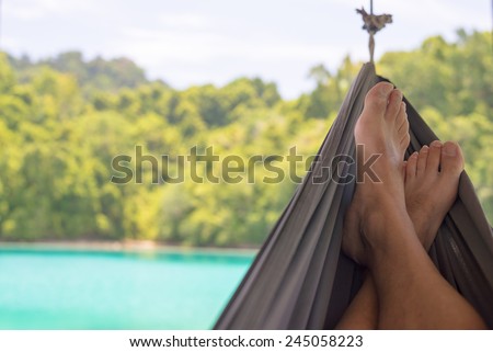 Man\'s feet on the hammock in the remote Togean Islands, Central Sulawesi, Indonesia.