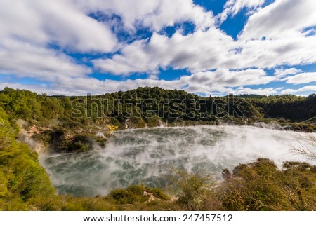 Frying Pan Lake, Waimangu Volcanic Valley, a steaming hot lake in the new born volcanic Echo crater with acid mineral rich water. Beautiful sky, wide angle view from above. New Zealand, Rotorua area.