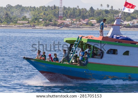 Ampana, Indonesia - August 23, 2014: People sitting on an obsolete ship heading to the Togean (or Togian) Islands, Central Sulawesi, Indonesia. Concept of travel safety in developing countries.