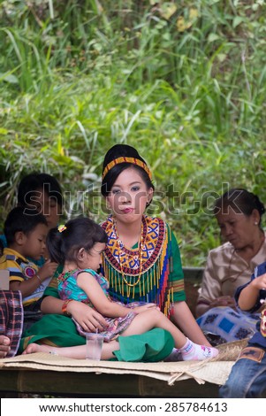 Sangalla, Indonesia - September 8, 2014: Portrait of young adult woman of Toraja ethnicity in traditional attire sitting and embracing little girl in Sangalla, Sulawesi, Indonesia.