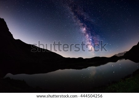 The outstanding beauty of the Milky Way arc and the starry sky reflected on lake at high altitude on the Italian Alps, Torino Province. Fisheye scenic distortion and 180 degree view.