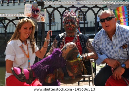 LONDON, UNITED KINGDOM - AUGUST 23: Punk with a lot of Piercings and Tattoos with tourists in Camden Town on August 23, 2009 in London, United Kingdom-